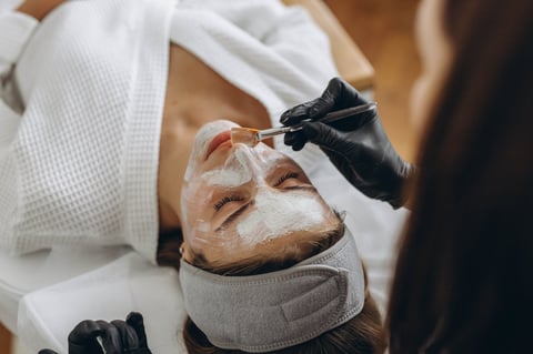 Woman receiving facial treatment at spa