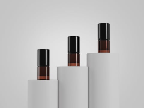 1 ml amber glass liquid containers mockup, set of small empty labeled brown glass bottles packaging display on pedestal, short tube containers isolate on clean background, sample product bottle mockup